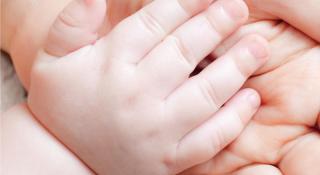 een kinderhand in een hand van een volwassene